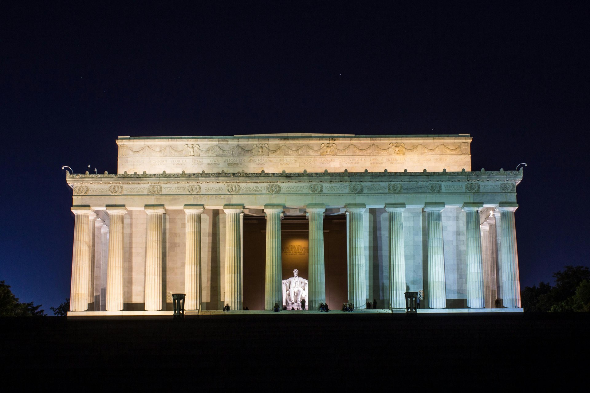 Lincoln Memorial illuminated at night with the Lincoln statue glowing through the columns